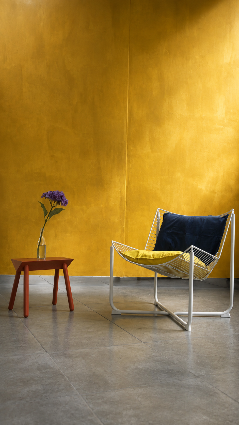 Set editorial con silla wire y florero sobre fondo amarillo mostaza — L'ATELIER 64 Bogotá